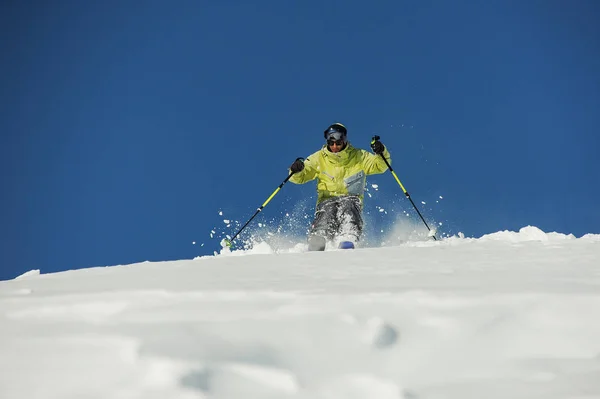 アクティブなスキーヤーはジョージア州グダウリ晴れた日に山の斜面の下の乗車明るい黄色のスポーツウェアに身を包んだ — ストック写真