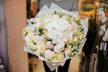 Büyük bir buket ihale beyaz çiçek tutan genç kız