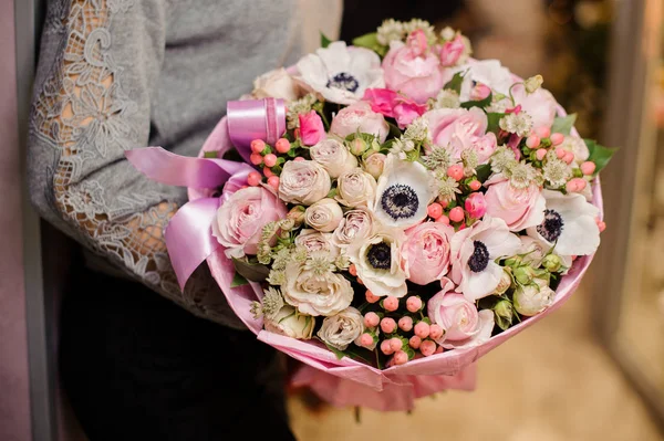 Jeune fille tenant un bouquet de fleurs de couleur rose tendre — Photo