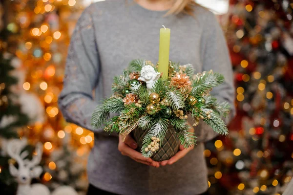 Ung flicka håller en jul sammansättning av guld inredning och Gran — Stockfoto