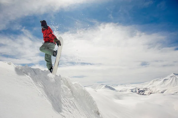 跳跃滑雪板保持他的一只手在滑雪板上的惊人的蓝天背景 — 图库照片
