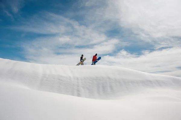 Два Молодых Сноубордиста Стоят Холме Сноубордами Руках Фоне Ясного Голубого — стоковое фото