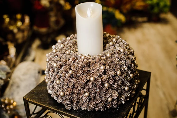 Vela de Natal queimando branco em um castiçal feito de cones de abeto e bolas — Fotografia de Stock