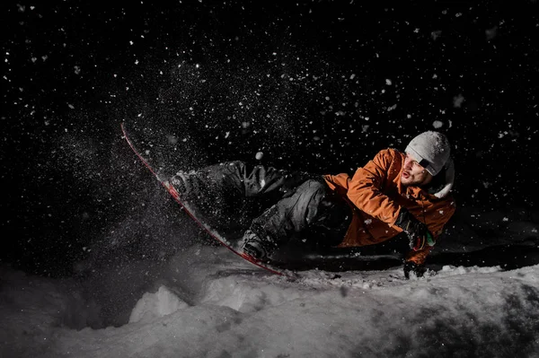 Junger Snowboarder Orangefarbener Jacke Auf Einem Schneebedeckten Pulverhügel Dunkler Nacht — Stockfoto
