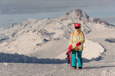 Pembeli kadın snowboard spor kask ve parlak renkli spor giyim dağlar tepeler karşı güneşli günde