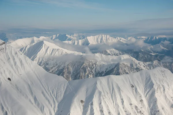 在格鲁吉亚古多里明亮的蓝天下覆盖着积雪的高纯冬季山脉的顶部视图 — 图库照片