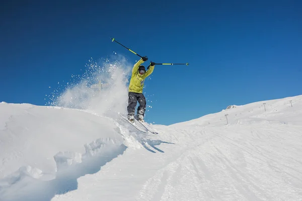明るい黄色いスポーツウェアとジョージアの山にジャンプ アップ グラスのプロのアクティブなスキーヤー — ストック写真