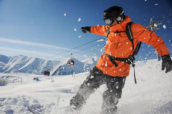 Snowboardzista Pomarańczowy Sportowej Jazdy Dół Stoku Góry Przeciwko Kolejki Linowej — Zdjęcie stockowe