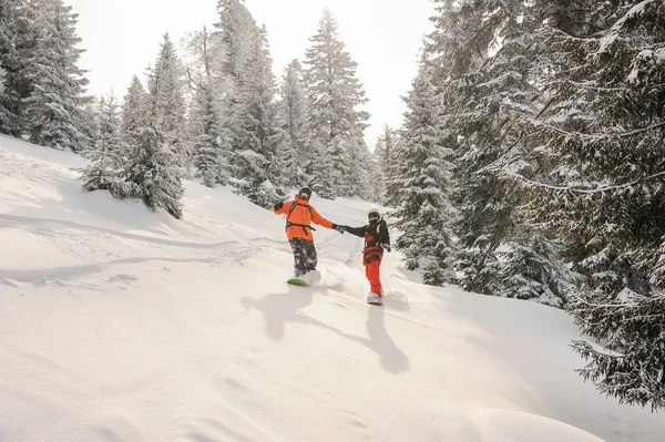 Dwa Snowboardzistów Działa Dół Wzgórza Trzymając Się Ręce Popularnej Miejscowości — Zdjęcie stockowe