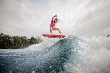 Arka plan gökyüzü ve ağaçlar üzerinde Nehri üzerinde sağlıklı yaz sahip wakeboard sürme aktif genç kız