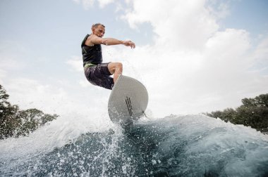 Etkin adam kadar gökyüzü arka plan üzerinde Nehri üzerinde sağlıklı yaz sahip Wave beyaz wakeboard atlama