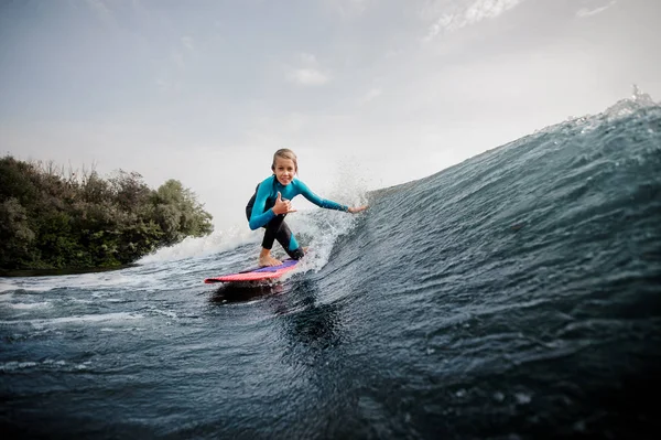 Aktiver Teenager Der Auf Einem Knie Auf Dem Orangefarbenen Wakeboard — Stockfoto