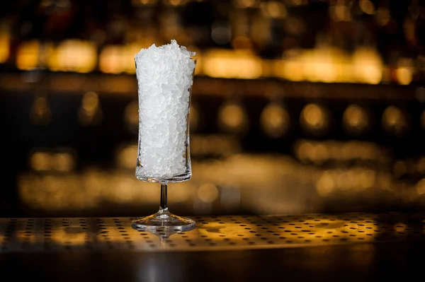 シェリーのコブラーのカクテル グラスがバーに氷で満ちている明るい金色の光に対するカウンター — ストック写真