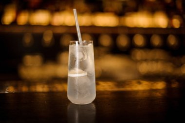 Şık uzun içki cam dolu Tom Collins barda kokteyl ile karşı karşı altın ışıkları