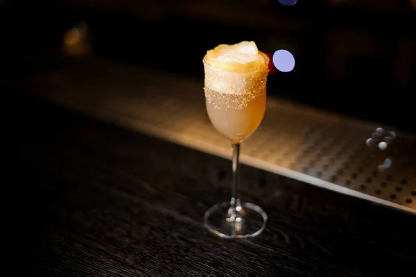 Weißes achoholisches Getränk im Cocktailglas mit braunem Zucker und Orangenschale — Stockfoto
