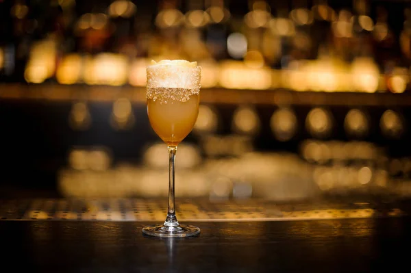 Ахолічний напій у склянці коктейлю прикрашений коричневим цукром та апельсиновою цедрою — стокове фото