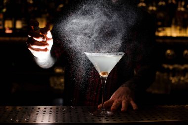 Bir kirli Martini çelik kokteyl için aroma özü ile püskürtme barmen sayaç karanlıkta bar