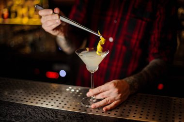 Barmen bir lezzetli White Lady cam bir portakal lezzet kokteyl çubuğu'nda cımbız ile ekleme sayaç