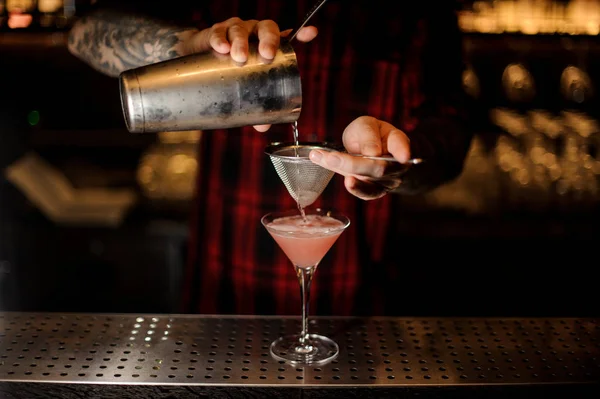Barman Pourring Cosmopolitan Shakerze Przez Sito Szkła Pasku Licznik Niewyraźne — Zdjęcie stockowe