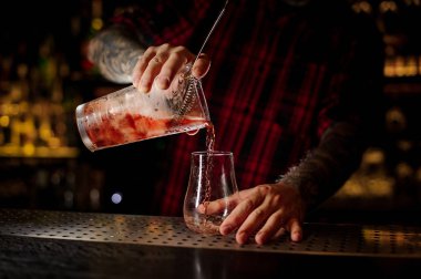 Barmen pourring bir kırmızı Sazerac kokteyl ölçüm fincan için çubuğu'nda bir cam sayaç