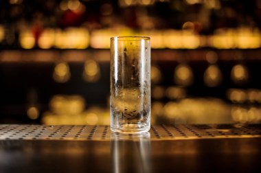 Boş çelik silindirik kokteyl cam duran karanlık ve aydınlık arka plan bulanık tezgaha bar