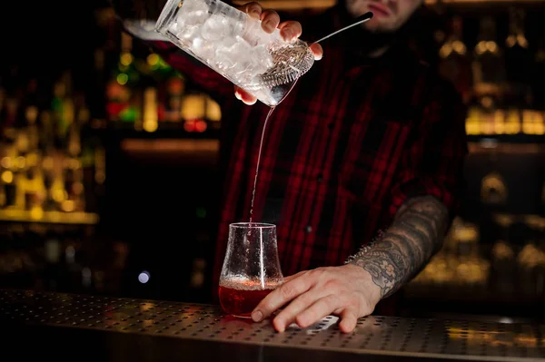 バーテンダー Pourring 氷と計量カップからカクテル Sazerac バーのガラス キューブ カウンター — ストック写真