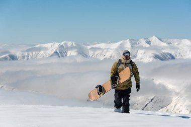 Mert snowboarder popüler turistik tatil Gürcistan'daki dağda kahverengi snowboard ile yürüme