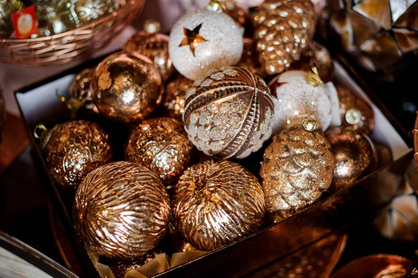 Doos van vele glinsterende witte en gouden speelgoed bollen van verschillende vormen — Stockfoto