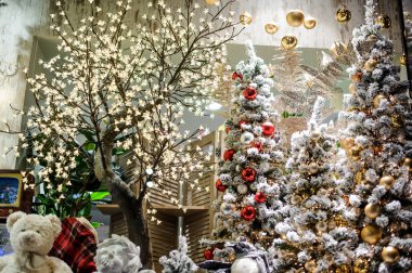 Buketler ve sevimli Hediyelik eşya ile bir çiçek dükkanında büyük ve güzel bir şekilde dekore edilmiş Noel ağaçları