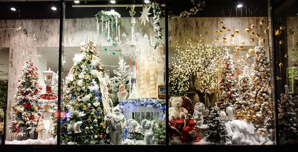 Beautiful and bright showcase of shop with many Christmas gifts, trees, toys, decorations and colorful garlands