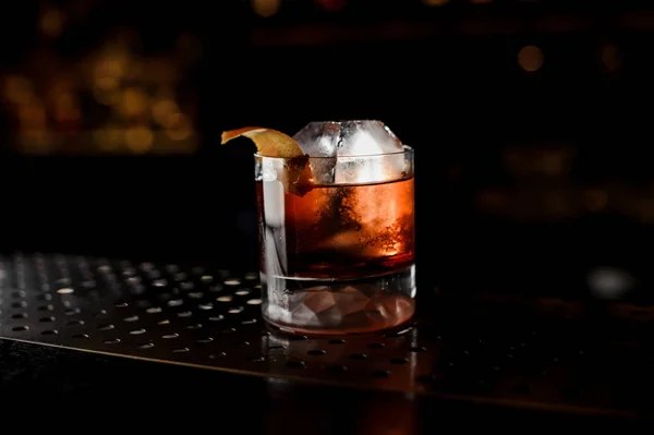 Glas av läckra färska och stark whiskey cocktail dekorerad med apelsinskal i mörk bakgrund — Stockfoto