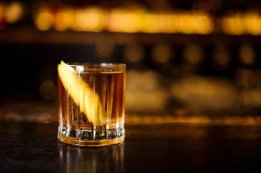 Güçlü kokteyl çubuğu ışıklar karşı hafif viski ile zarif düşük cam dolu