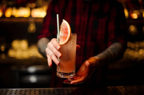 Barman, trzymając szklankę świeżych i kwaśną owoców koktajl alkoholowy z grejpfruta — Zdjęcie stockowe