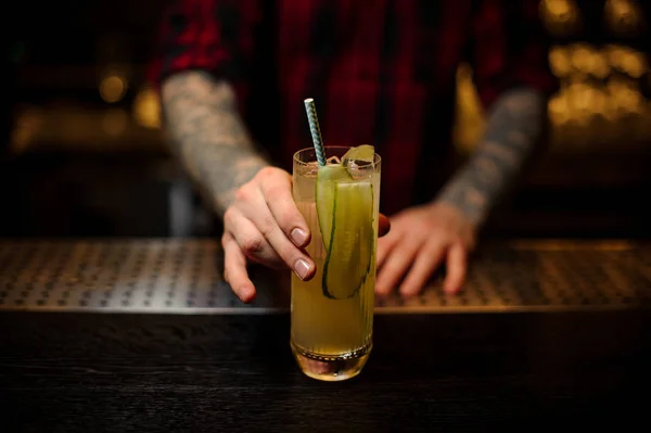 バーのカウンター キュウリ ジュース ジンと新鮮なアルコール カクテルを保持の入れ墨をしたバーテンダー — ストック写真