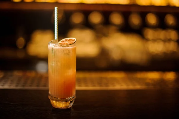 Copa de cóctel de limonada naranja con una rebanada de naranja fresca y paja — Foto de Stock