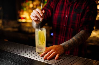 Salatalık taze alkollü kokteyl ve cin portakal suyu ile karıştırma çubuğu'nda barmen