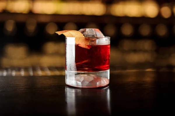 Copa de un cóctel Boulevardier con ralladura naranja en el mostrador de barra de acero y madera — Foto de Stock