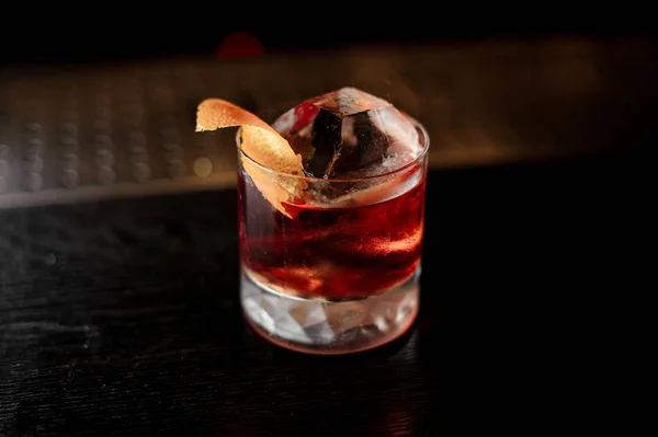 View from above glass of a Boulevardier cocktail with orange zest on the steel wooden bar counter — Stock Photo, Image