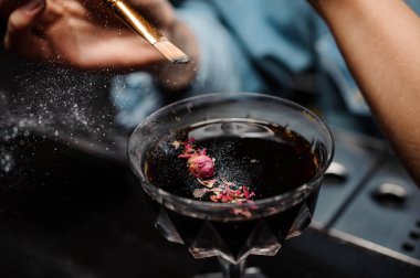 Kadın barmen bir glitter bir kokteyl cam alkollü içki ile fırça ekleme gül yaprakları ile dekore edilmiştir.