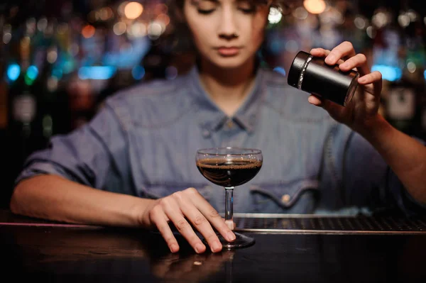 Vrouwelijke bartender toevoegen aan een cocktail met bruin alcohol een poeder op de balk teller — Stockfoto