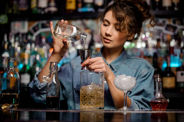 Barmen kız çelik banyo çubuğu'nda bir alkollü içki dökülen sayaç