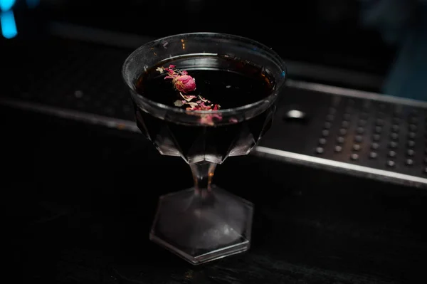 Koktejlové sklenice s alkoholický nápoj zdobený okvětními lístky růží — Stock fotografie