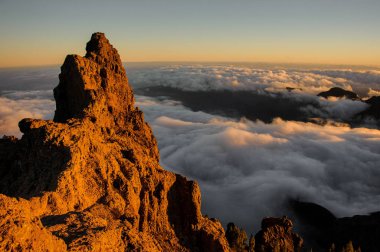 Gran Canaria, İspanya - 6 Kasım 2018: Sabah manzara bulutlar arasında güneş ışığı altında Roque Nublo Dağı