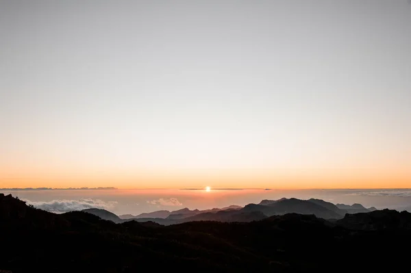 GRAN CANARIA, ESPANHA - NOVEMBRO 6, 2018: Paisagem matinal da montanha Roque Nublo com vista para a bela ilha de Tenerife em raios de sol — Fotografia de Stock