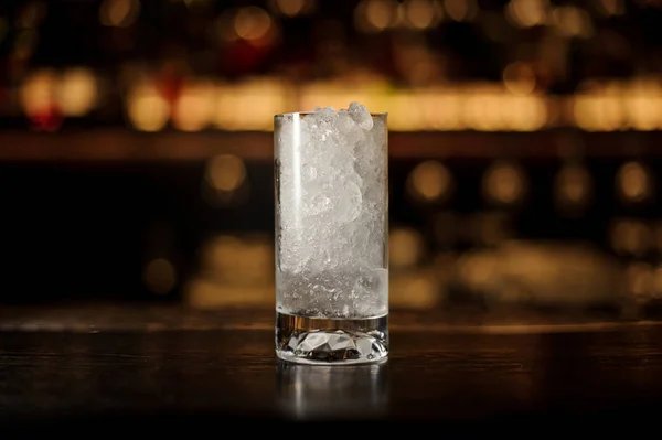 Glass of crushed ice standing on the empty bar counter