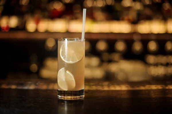 Стакан лимонадного коктейля с апельсинами на деревянном барной стойке — стоковое фото