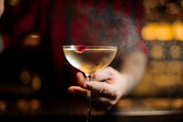 Barman sosteniendo elegante copa de cóctel con bebida alcohólica — Foto de Stock