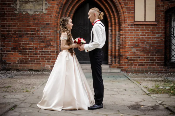 Casal elegante em pé e sorrindo no fundo do arco do edifício velho — Fotografia de Stock