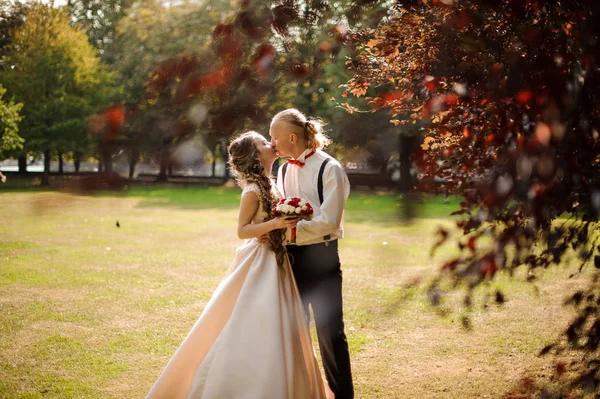 Feliz casal se beijando em um campo de grama verde com árvores — Fotografia de Stock