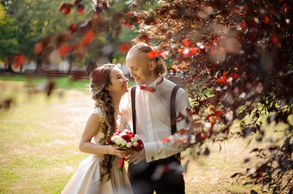 Casal sorrindo casal andando em um parque verde — Fotografia de Stock